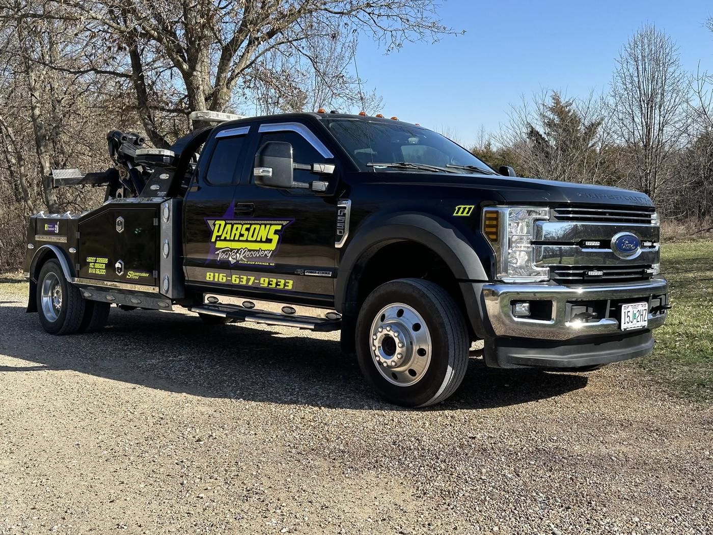 Black Ford F-550 heavy wrecker number 111 with the purple and yellow Parsons logo