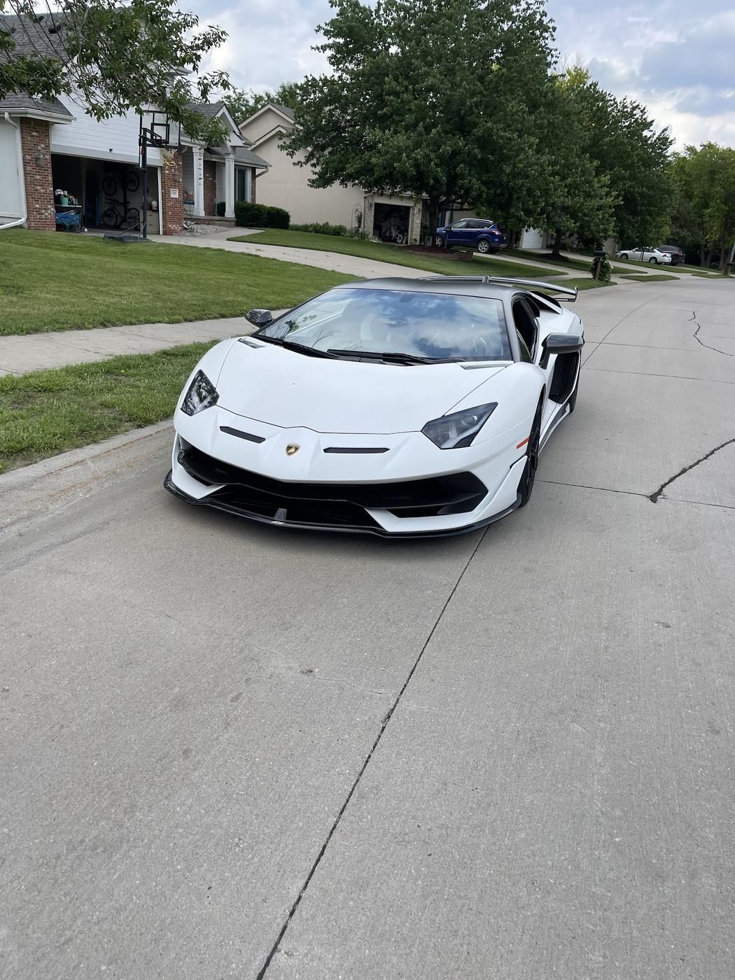 White Lamborghini parked on a residential street before loading